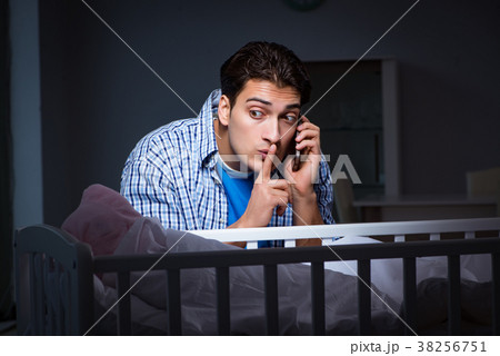 Happy dad looking after newborn baby at night 38256751
