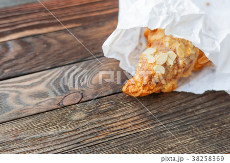Tasty croissant in white paper bag on table. Tasty croissant in white paper bag on table. 38258369