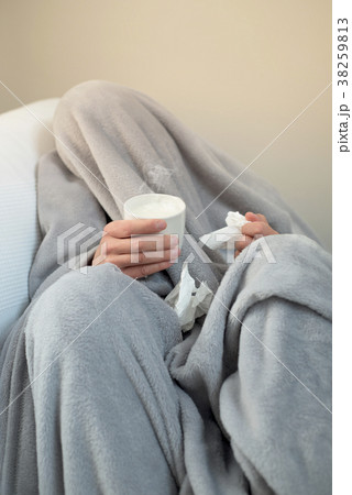 ill man warming up with a cup of hot milk 38259813