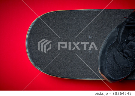 shoes and used skateboard on a red background shoes and used skateboard on a red background 38264545