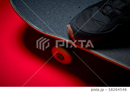 shoes and used skateboard on a red background 38264546