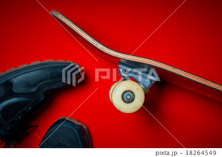 shoes and used skateboard on a red background 38264549