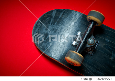 used skateboard on a red background 38264551