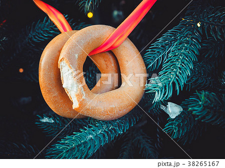 Two bitten off bagels on a ribbon hang on a 38265167