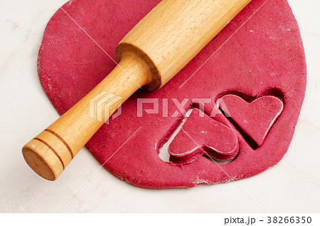 Red beet dough with two cut hearts out Red beet dough with two cut hearts out 38266350