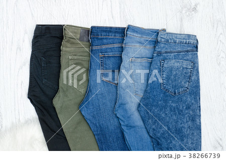 Five blue jeans on wooden background 38266739