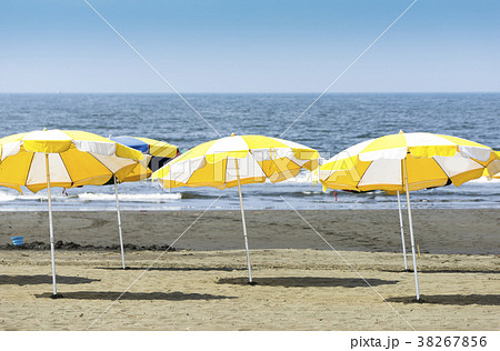 砂浜の黄色いビーチパラソルの写真素材