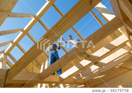 Builders at work with wooden roof construction. Builders at work with wooden roof construction. 38279758