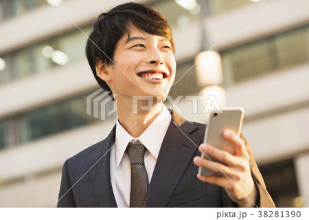 夕暮れ時に電話するビジネスマン 夕暮れ時に電話するビジネスマン 38281390