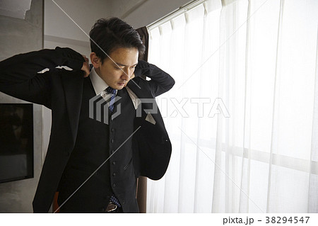 スーツの上着を着るお洒落なビジネスマン　 38294547