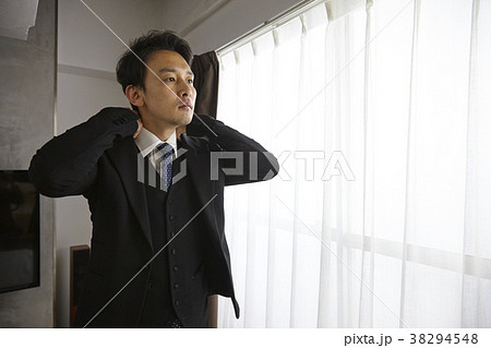 スーツの上着を着るお洒落なビジネスマン　 38294548