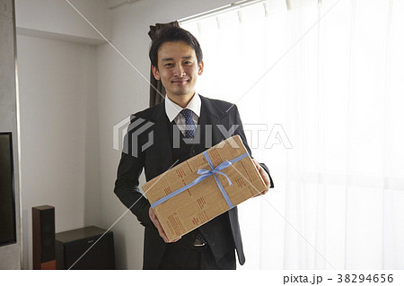 プレゼントを渡すお洒落なビジネスマン　 38294656