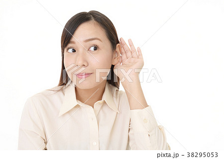 耳に手を当てる女性の写真素材