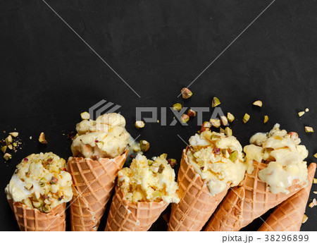 Vanilla ice cream in waffle cone with nuts  38296899