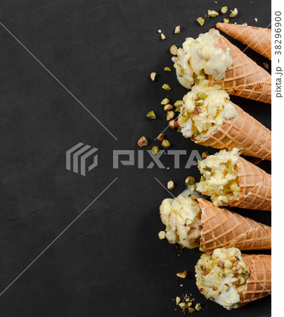 Vanilla ice cream in waffle cone with nuts 38296900