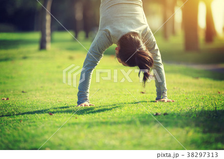 woman practice handstand on park meadow 38297313
