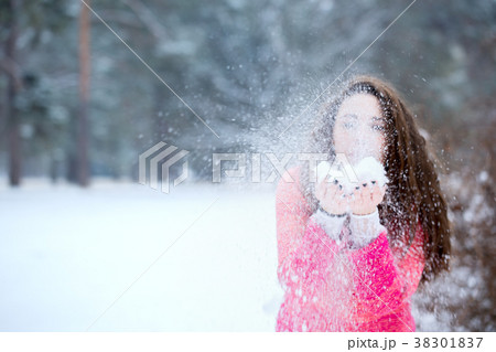 Beautiful woman blowing on the snow 38301837