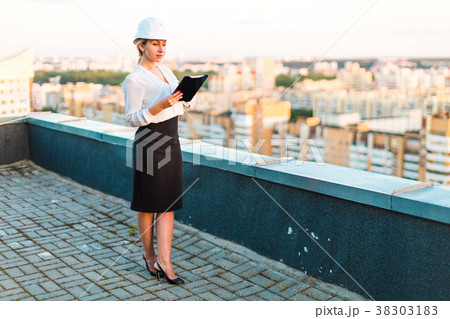 Pretty young forewoman in helmet stand on the roof Pretty young forewoman in helmet stand on the roof 38303183