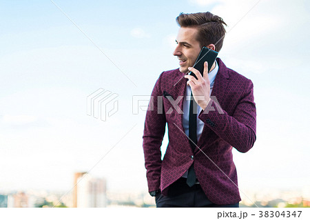 Young serious businessman in red suit and shirt Young serious businessman in red suit and shirt 38304347