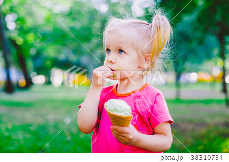 little funny girl blonde eating sweet blue ice 38310734