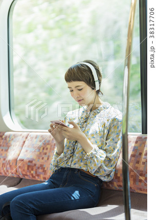 電車で音楽を聴く女性 38317706