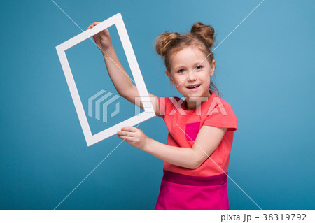 Beautiful cute little girl in pink dress holds 38319792