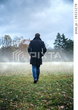 the man is walking on the field 38321279