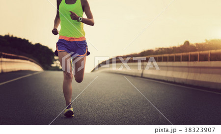 fitness asian woman runner running on city road 38323907