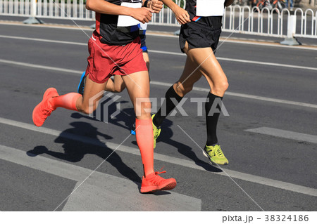 marathon runners legs running on city road 38324186