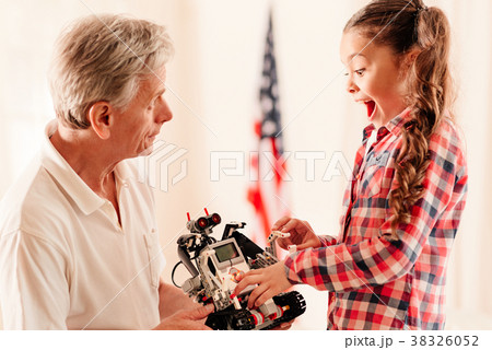 Emotional little girl getting excited over robot Emotional little girl getting excited over robot 38326052