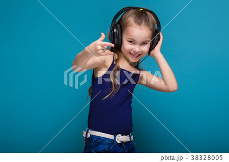 Pretty, little girl in shirt and earphones with 38328005