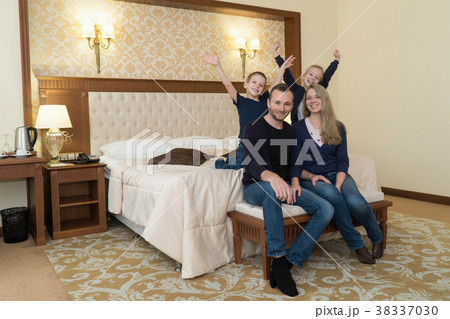 a happy family posing on camera in hotel room 38337030