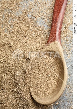 Top view of a wooden spoon full of grind black 38337033
