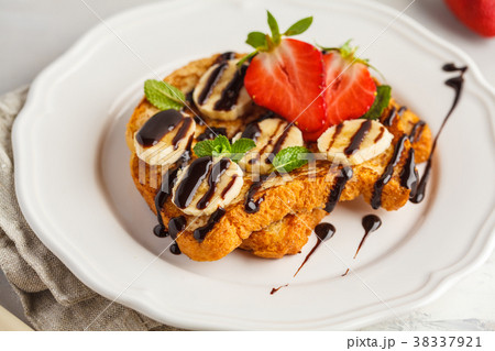 French toasts with chocolate syrup, strawberries 38337921