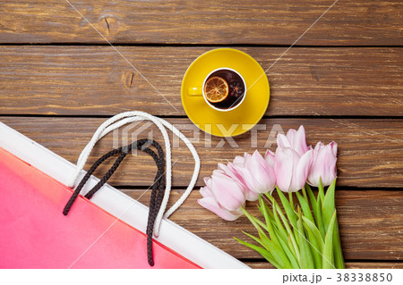 Cup of english tea with spring tulips and shopping bags Cup of english tea with spring tulips and shopping bags 38338850
