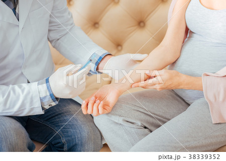 Concentrated responsible doctor sitting and making 38339352