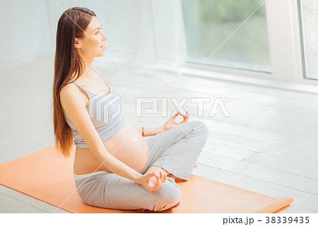Pleasant young woman mediating on the floor and 38339435