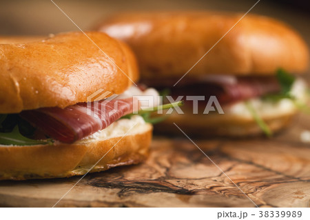 two bagels with prosciutto and cream cheese on 38339989