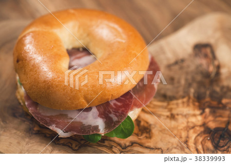 bagel with coppa and cream cheese on wood boar 38339993