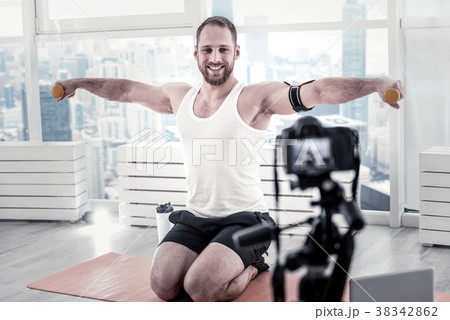 Merry male blogger lifting dumbbells Merry male blogger lifting dumbbells 38342862