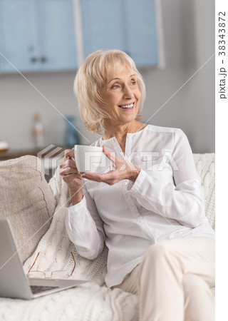 Dreamful mature woman distracting from laptop Dreamful mature woman distracting from laptop 38343872