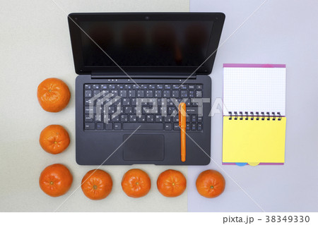 Laptop, notebook, pen and tangerines  38349330
