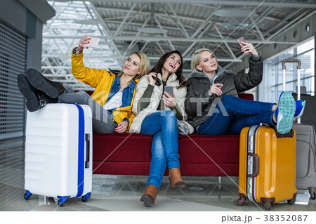 Smiling girls photographing themselves on mobile 38352087