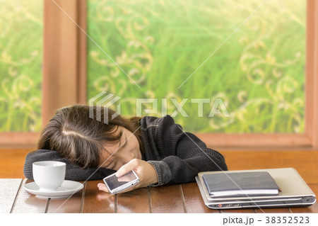 Asian girl sleeping and hold smartphone in hand Asian girl sleeping and hold smartphone in hand 38352523