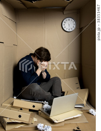Hopeless businessman is crying in small cardboard 38353467