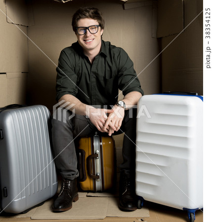 Positive guy is waiting for flight in cardboard 38354125