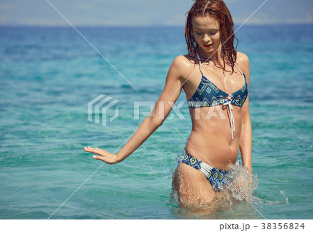 Young woman in bikini by tropical sea Young woman in bikini by tropical sea 38356824