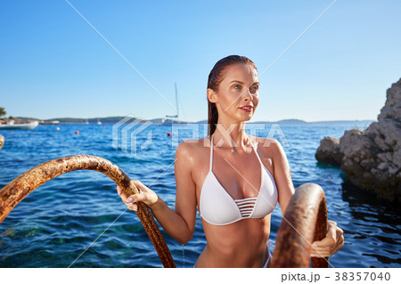 Elegant Woman in the White Bikini on the Sun-tanned Slim and