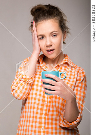 studio portrait of a sleepy woman in an orange 38358323