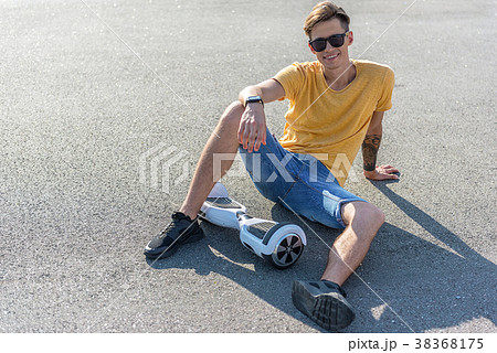 Outgoing boy situating near hoverboard 38368175